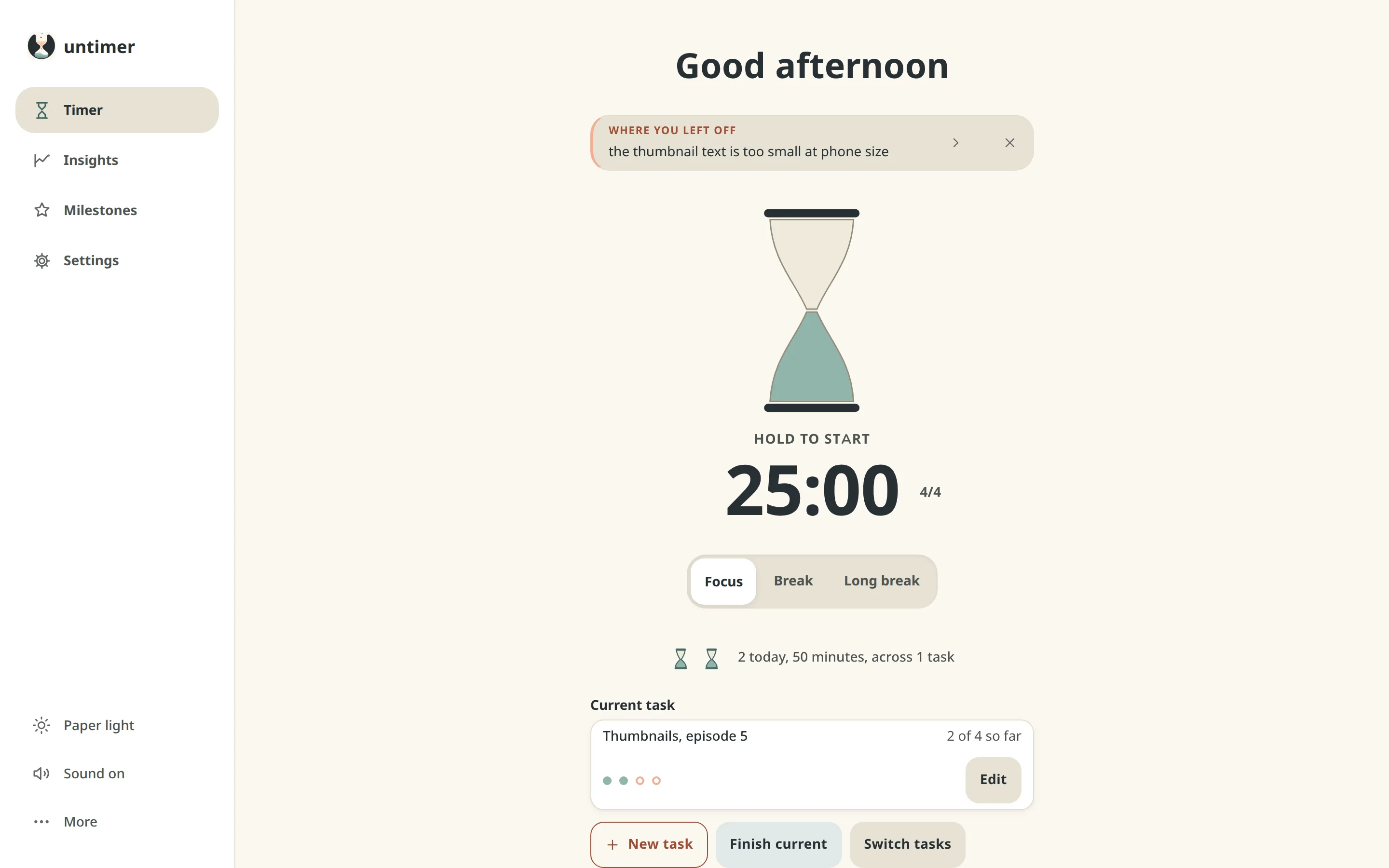 The Timer screen: the message box under the greeting with a line from the last interruption, the hourglass at rest, 25:00 with the set figure, the Focus, Break and Long break selector, two small hourglasses for today, and the current task at two of four.
