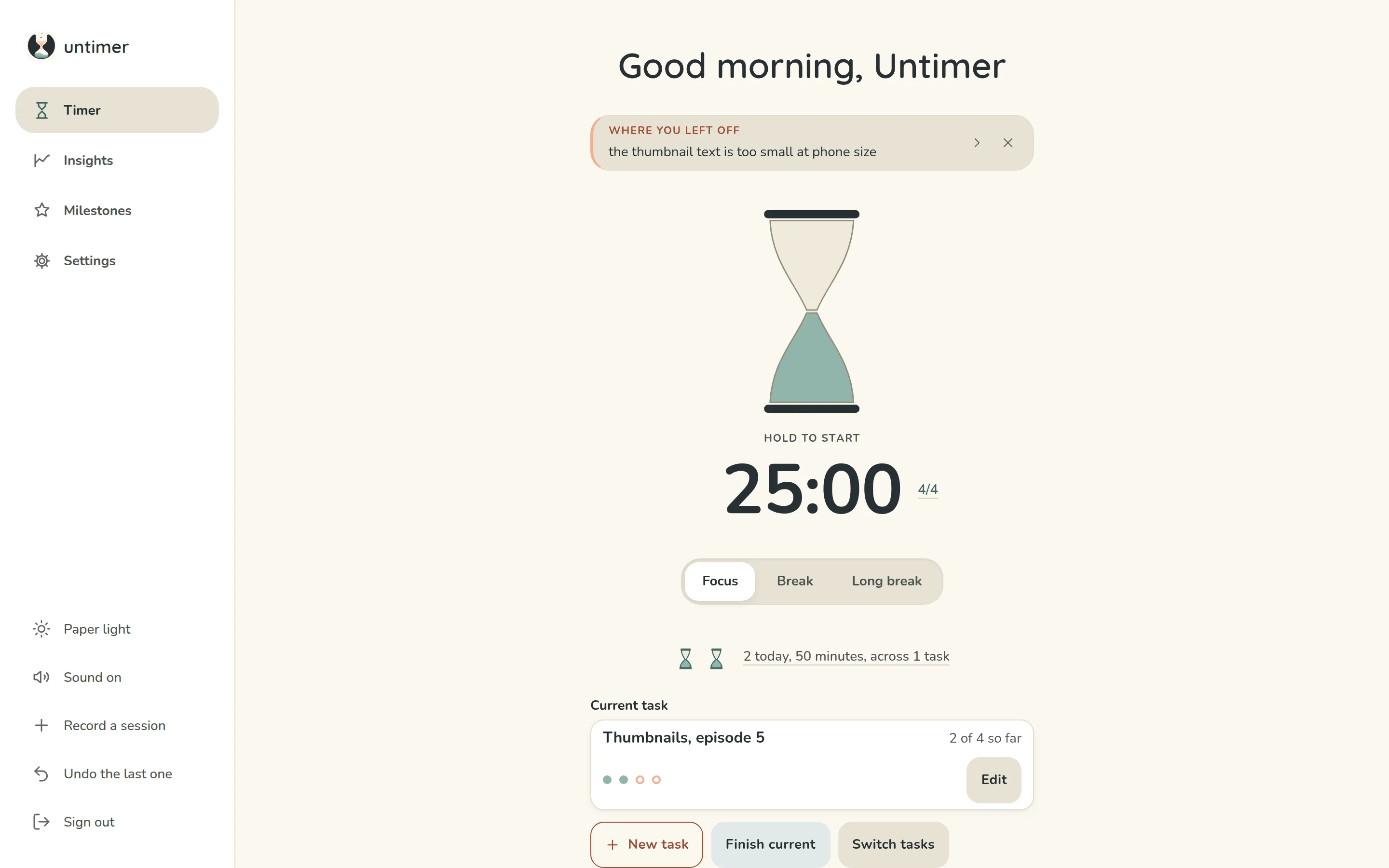 The Timer screen of Untimer on a Saturday morning: a greeting, the box under it holding a line written at the last interruption, the hourglass at rest with Hold to start under it, 25:00, the set figure 4/4, a Focus, Break and Long break selector, two small hourglasses for the two sessions of the day so far, and the current task, Thumbnails episode 5, at two of four sessions.